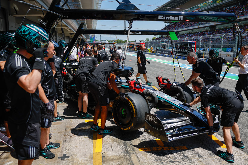 Formel 1-bil blir dyttet inn i garasjen.