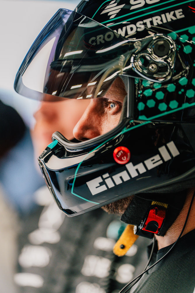 Et Formel 1-mannskapsmedlem har på seg hjelm og ser fokusert til siden.
