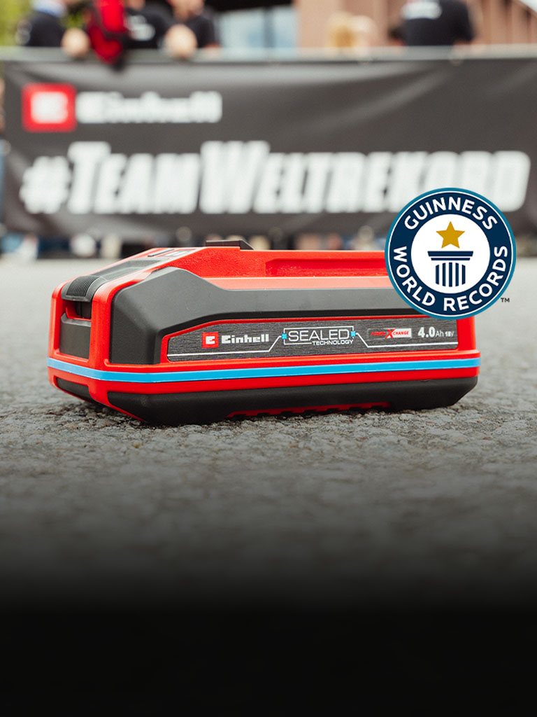 Einhell SEALED-batteri Power X-Change 4,0 Ah ligger på asfalten, med logoen “Record Holder” for Guinness World Records til høyre.